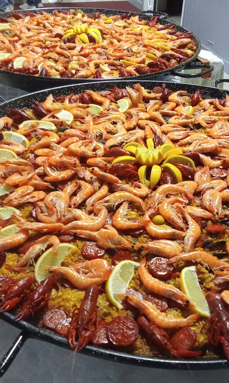 Grandes paëllas traiteur garnies de crevettes et citron